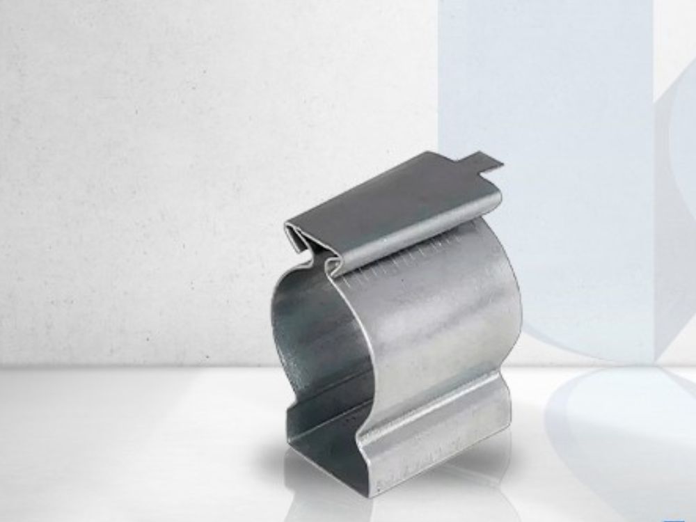 Abraçadeira metálica tipo clip para fixação de conduítes e tubos, com acabamento galvanizado e sistema de encaixe superior.