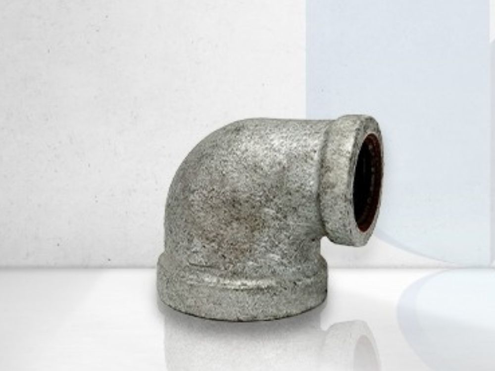Conexão joelho galvanizado 90 graus com rosca interna, usada em sistemas hidráulicos e redes de tubulação em aço galvanizado.
