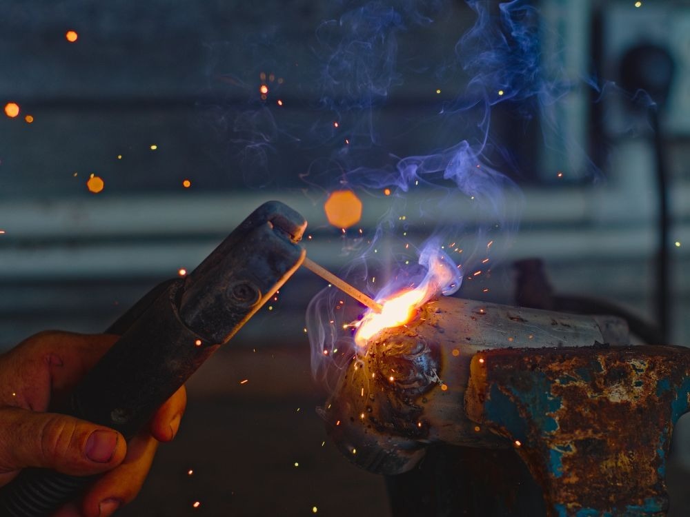 Soldagem industrial com faíscas intensas ilustrando a diferença entre solda MIG e MAG na aplicação em estruturas metálicas pesadas.