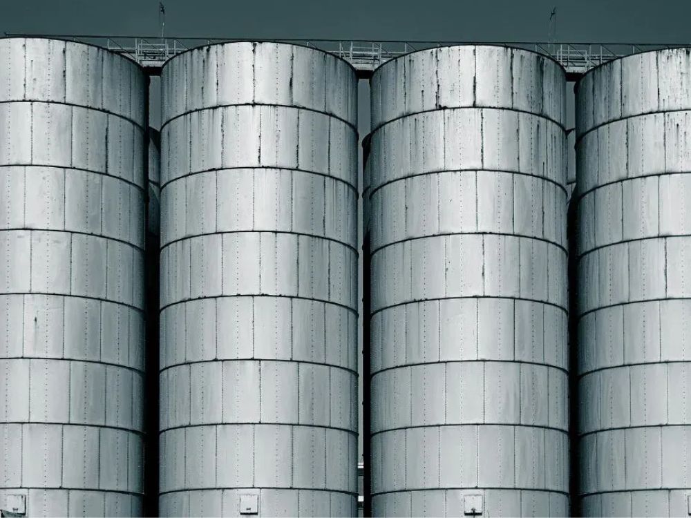 Estruturas metálicas galvanizadas em tanques industriais expostos, reforçando que aço galvanizado pode molhar com resistência.