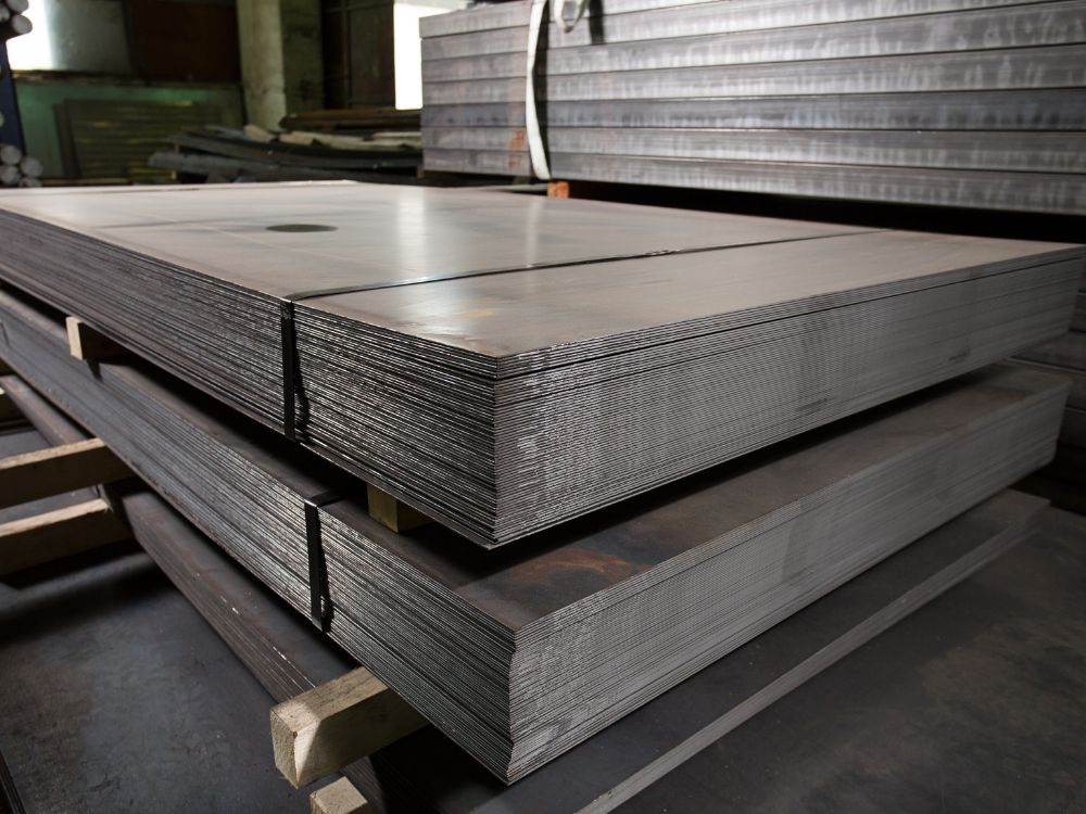 Pilhas de chapas metálicas laminadas mostrando diferentes espessuras, representando Tipo de chapa de aço para construção e indústria.